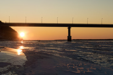 bridge over the river in winter at sunset