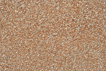The texture of the wall is made of small orange and white stones.