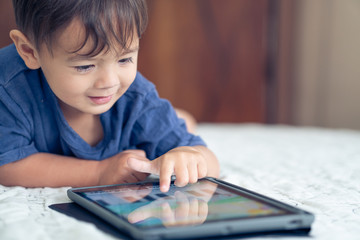 cute young mixed race boy playing with an electronic device