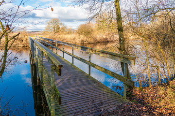 Holzbrücke über Altarm der Schussen; strahlend blauer Himmel über dem Naturschutzgebiet...