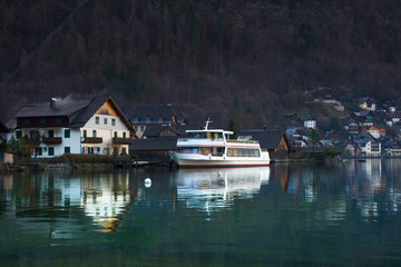 Fototapeta premium Hallstatt, a charming village on the Hallstattersee lake and a famous tourist attraction, with beautiful mountains surrounding it, in Salzkammergut region, Austria, in winter sunny day.