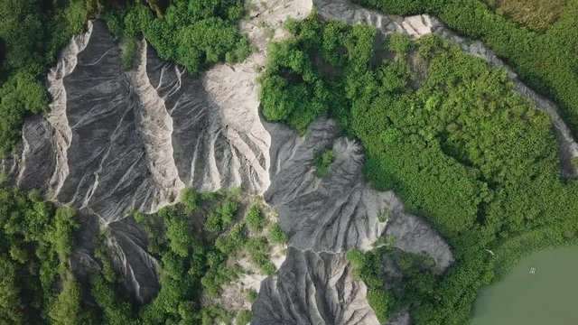 Top Down Aerial View of Grey Mudstone Cliff and Green Forest Foliage in Tianliao Moon World Landscape Park, Taiwan