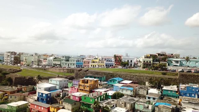 Pull Back Aerial View of La Perla, Shanty and Colorful District of San Juan Puerto Rico on Atlantic Ocean Coastline