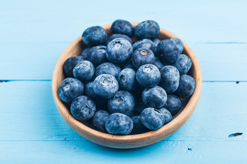 Fresh organic blueberries in wooden bowl