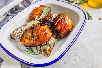 Grilled chicken drumstick bbq with rosemary on a stone gray background.