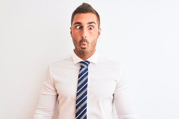 Young handsome elegant business man over isolated background making fish face with lips, crazy and comical gesture. Funny expression.