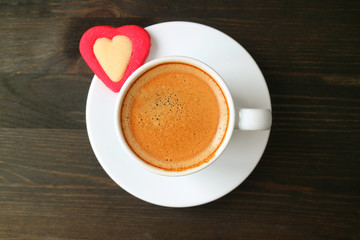 Top View of a Cup of Espresso Coffee with Red Heart Shaped Cookie on Dark Brown Wooden Table for Valentine's Day Concept