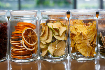 Dried oranges and apples in glass jars.