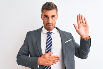 Young handsome business man wearing suit and tie over isolated background Swearing with hand on...