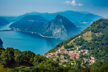 Fototapeta na wymiar The village of Bre, Lugano Lake , and famous mountains of this area. Beautiful aerial view of a large lake, Swiss village and surrounding high mountains. The photo was taken above the village Bre.