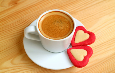 One Cup of Espresso Coffee with a Pair of Red Heart Shaped Cookies on Wooden Table for Valentine's Day Concept