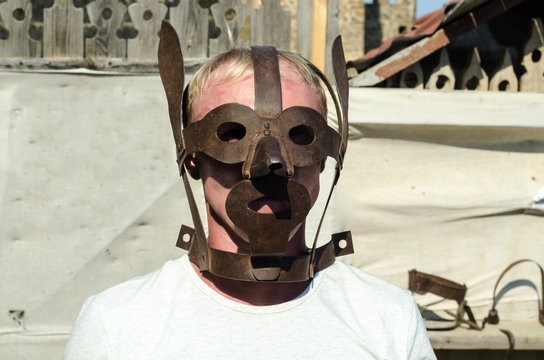 medieval torture mask on blond man