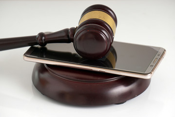wooden gavel, smartphone and law books