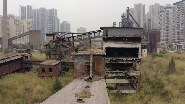 Abandoned steel factory mill with conveyor in between living apartment blocks, Guangzhou, China, Aerial shot.