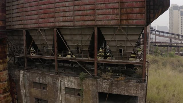 Fly around abandoned steel plant metal structures with  in between living apartment blocks, Guangzhou, China, Aerial shot.