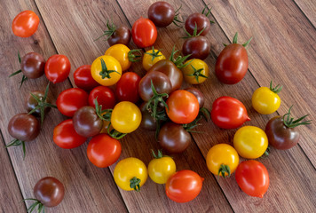 Different colors and shapes of fresh tomatoes on a wooden table. Vegan vegetarian diet. Garden.