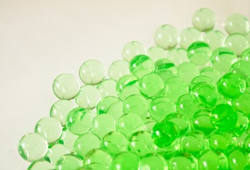 Green water beads on a white background