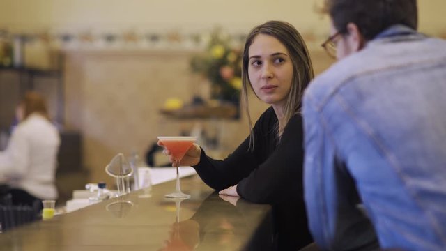 A young cute guy is trying unsuccessfully to flirt and hit on a cute married lady in a pub. 4K