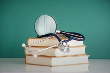 medical books, stethoscopes and magnifying glasses