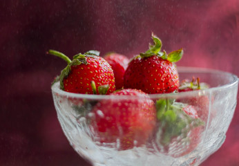 strawberries in glass bowl isolated on white.