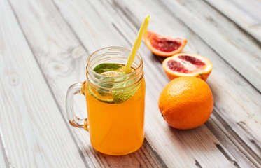 Fresh orange on a wooden background. Juice in a jar. Summer drink. Orange on a wooden background.