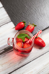 Strawberry juice on a wooden background. Summer drink.