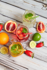 Summer drinks. Fresh freshes on a wooden background. View from above. Orange, lemon and strawberry fresh.