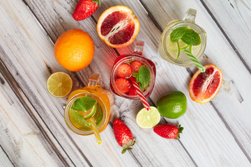 Summer drinks. Fresh freshes on a wooden background. View from above. Orange, lemon and strawberry fresh.