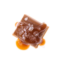 Delicious salted caramel with sauce on white background, top view