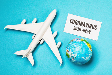 Toy airplane, globe and a sheet of paper with the inscription. Conception on 2019 coronavirus...