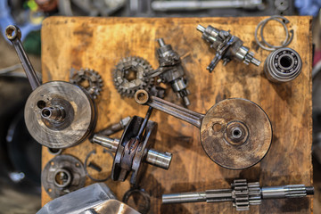 Engine parts of an old motorcycle are spread out on the table
