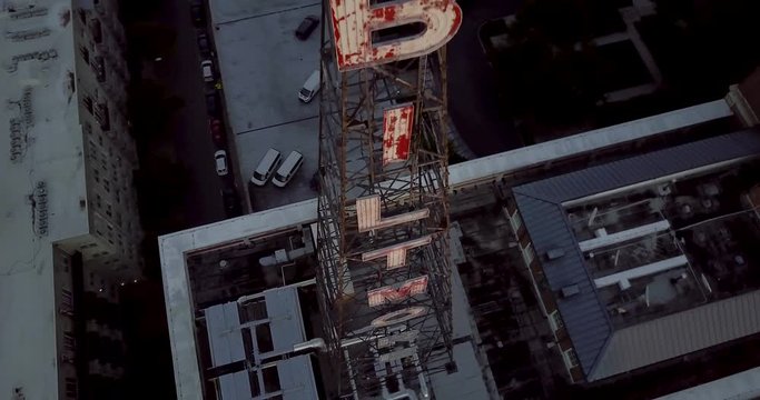 Vintage peeling paint on a neon sign tower on top of building in downtown Atlanta. Aerial Drone Decending Orbit