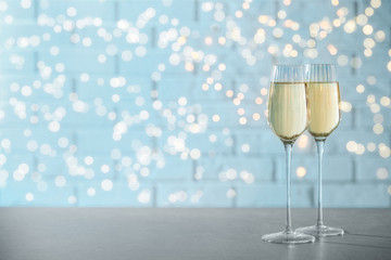 Glasses of champagne on grey table. Space for text