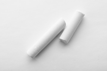 Pieces of chalk on white background, top view