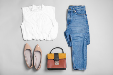 Stylish outfit with jeans on light grey background, flat lay