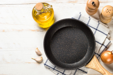 Frying pan or skillet on white wooden table.