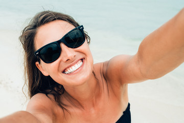 Close up shot of happy smiling female tourist. Poses for selfie