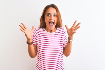 Young redhead woman wearing striped casual t-shirt stading over white isolated background...