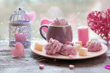 Two cups of coffee with meringues and marshmallows, Turkish delight on a plate, hearts, illumination, against the background of a window, homeliness, Valentine's day, romantic greeting, happy birthday