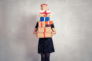 Woman is holding a heap of gift boxes. Celebration and shopping concept.