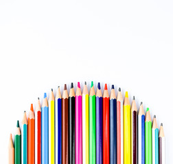 Color pencil arranged in a waved formation over a white isolated background
