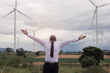 Fototapeta na wymiar Success african business man raised arms with wind turbine.