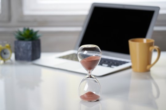Hourglass on office desktop.