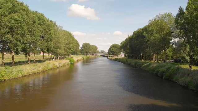 Drone shot above schelde river in Belgium with blue sky and