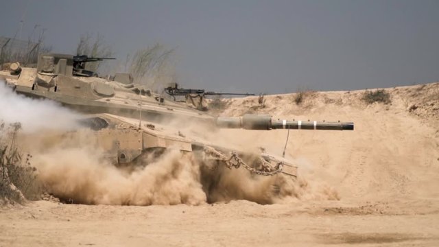 Powerful military tank in fighting action at the desert. slow motion