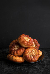 Fried peremyachi, belyashi, pies on a black background. Traditional Russian pies. Russian, Bashkir and Tatar cuisine. Copy space. © Анна Скворцова