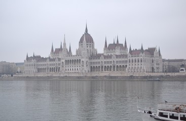 Fototapeta premium Ship on Danube river, Parliament in the fog background