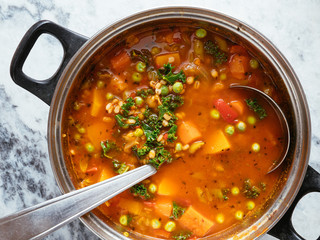 Home made Italian winter minestrone soup with winter squash, carrots, kale, green beans, peas,...