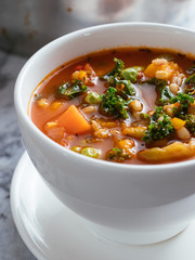 Home made Italian winter minestrone soup with winter squash, carrots, kale, green beans, peas,...