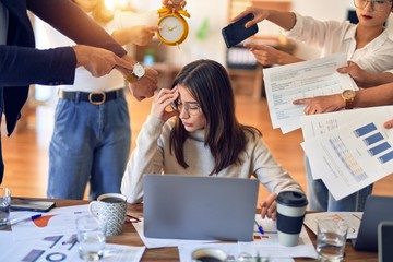 Group of business workers working together. Partners stressing one of them at the office